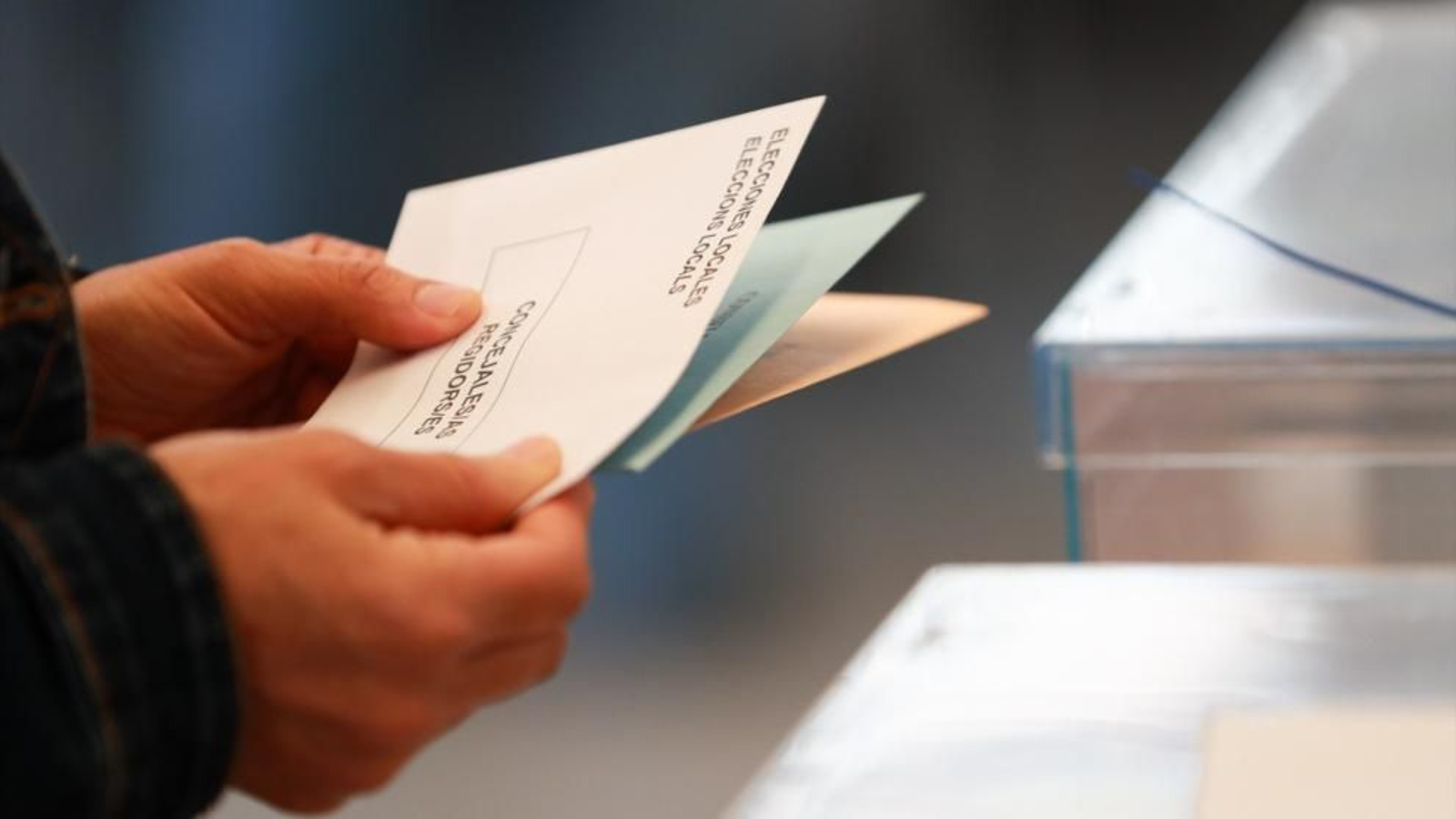Una persona sostiene papeletas electorales frente a las urnas, el 28 de mayo de 2023.
