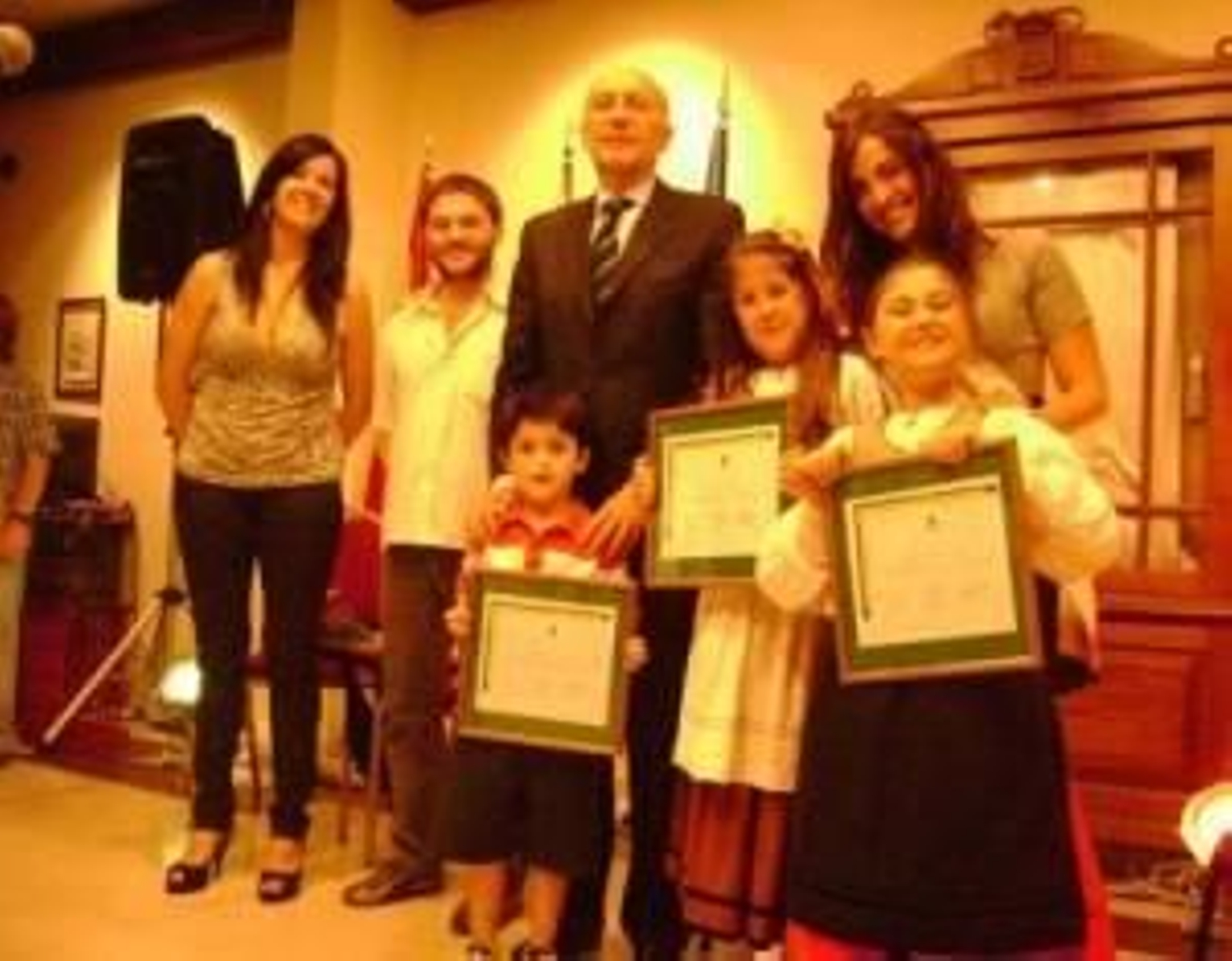 Niños homenajeados en el acto posan junto al cónsul, Manuel Fairén.