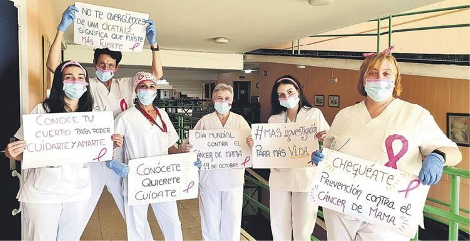 Personal de la residencia Nuestra Señora de la Esperanza con carteles motivadores en el día contra el cáncer de mama.