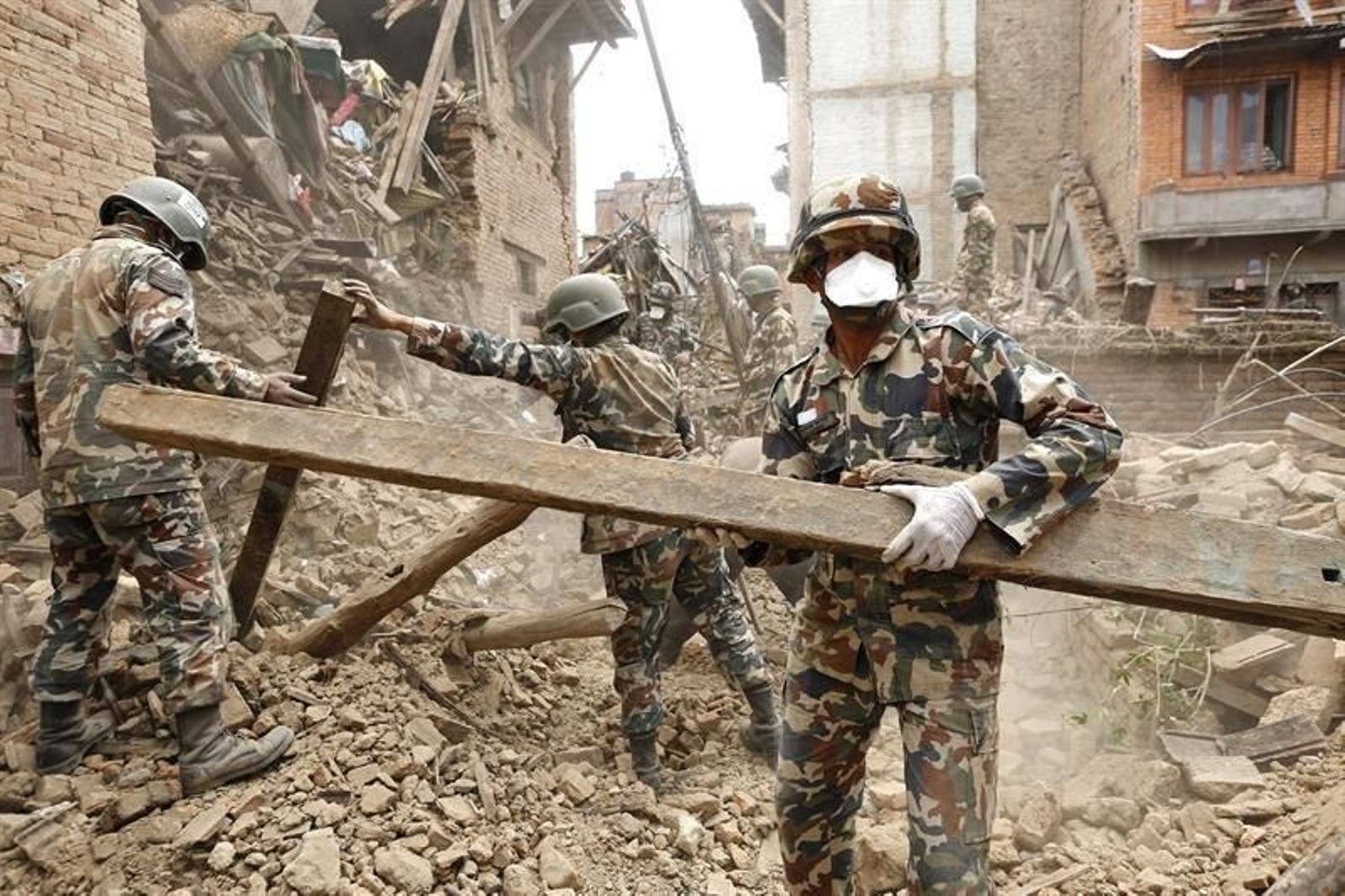 Varios soldados nepalíes participan en una operación de rescate en un edificio derrumbado por el seísmo que ha golpeado el país asiático, en Shaku. (EFE)