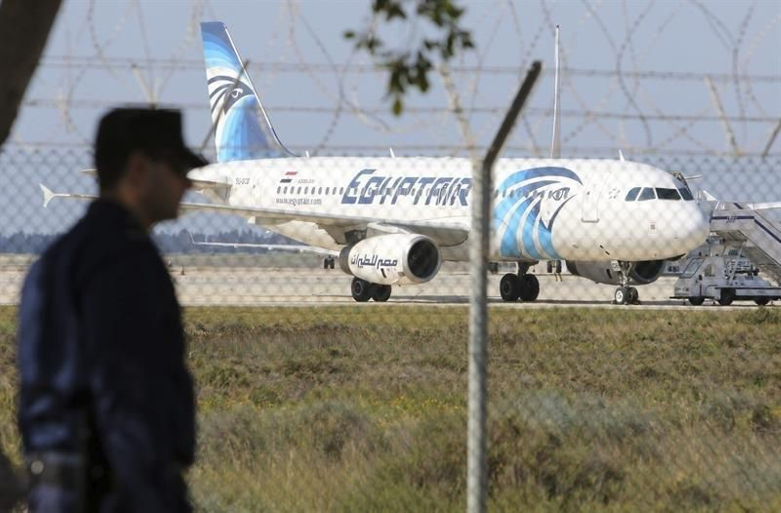 Un policía monta guardia cerca del avión de Egiptair secuestrado por un pasajero con un cinturón explosico en el aeropuerto de Larnaca (Chipre).