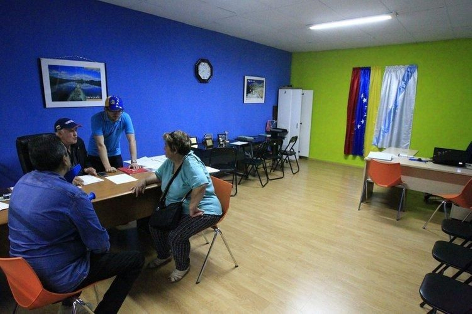 Dos personas reciben información en la oficina de las galerías Proyflem.