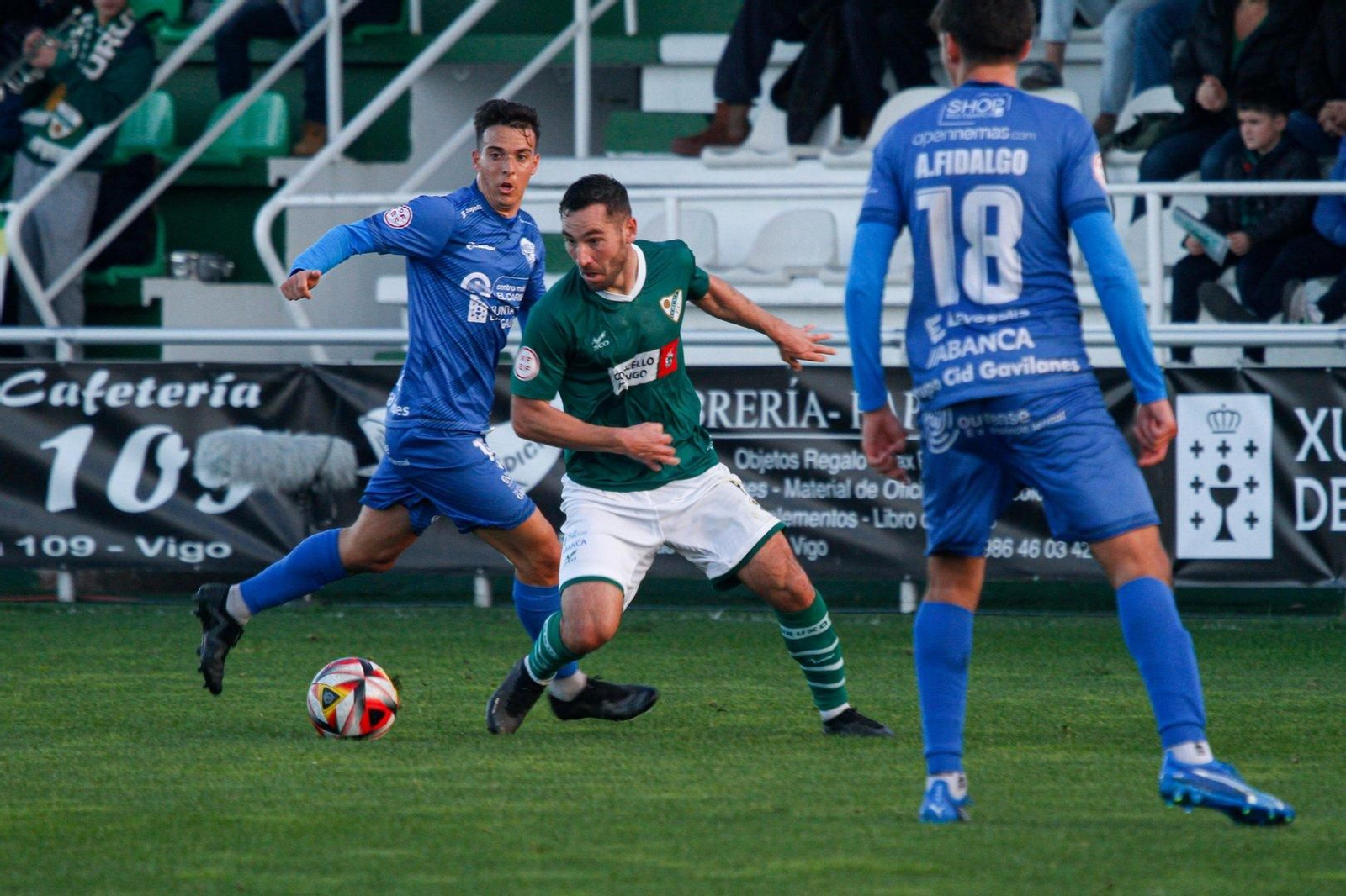 David Añón realiza un regate entre dos rivales en un partido de la presente campaña disputado en O Vao.