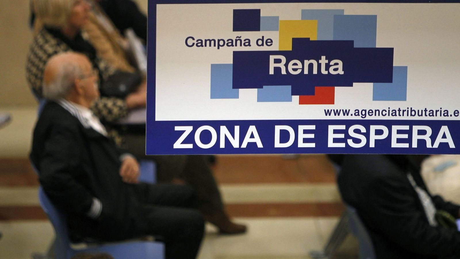 Varias personas esperan en la sala de espera de la Agencia Tributaria para hacer la declaración de la renta.