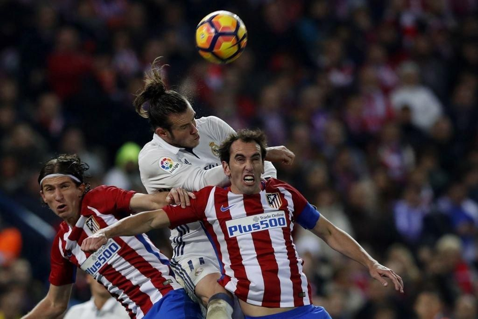 Bale trata de cabecear el esférico ante los jugadores del Atlético de Madrid Filipe Luis y Godín.