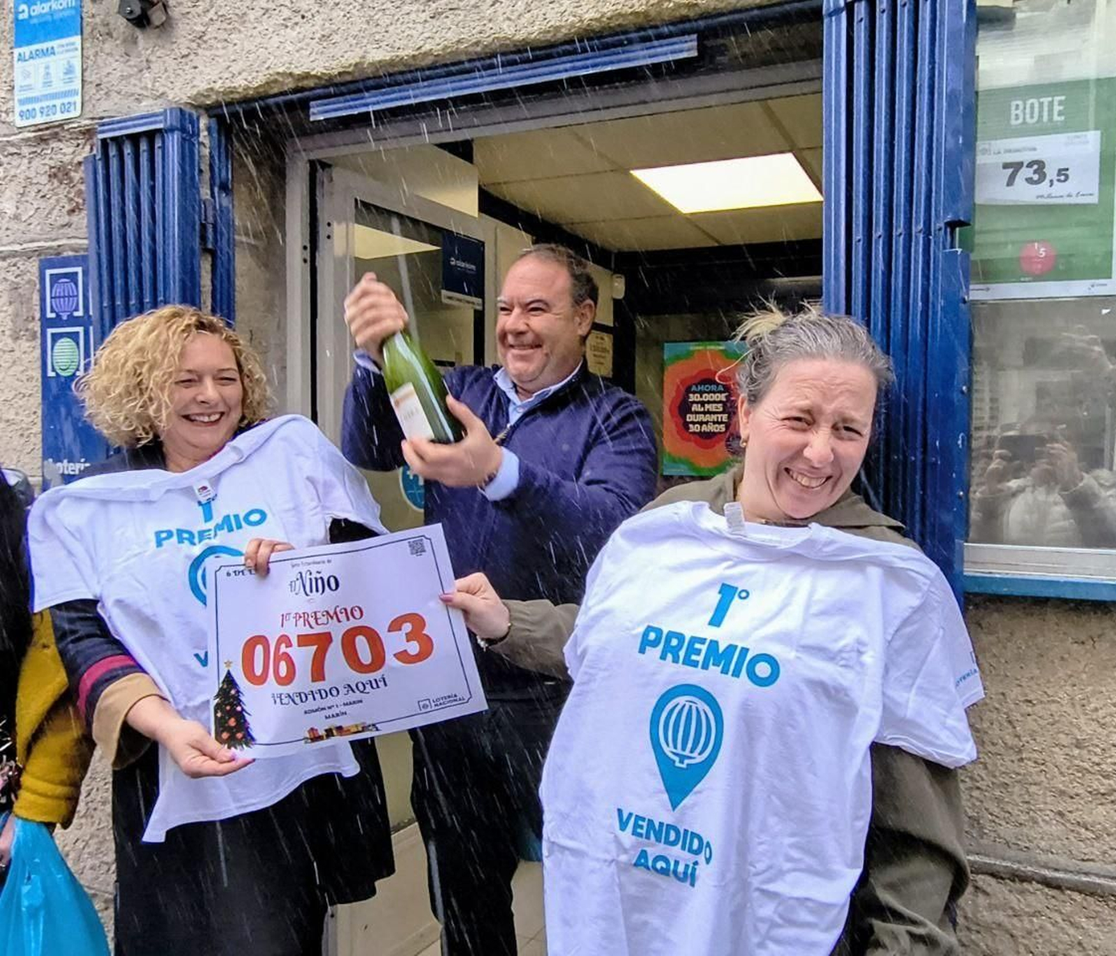 Peregrina Pereira, Alejandro y María, de la Administración Tica número 1 de Marín, celebrando el reparto de millones con el número 06703.