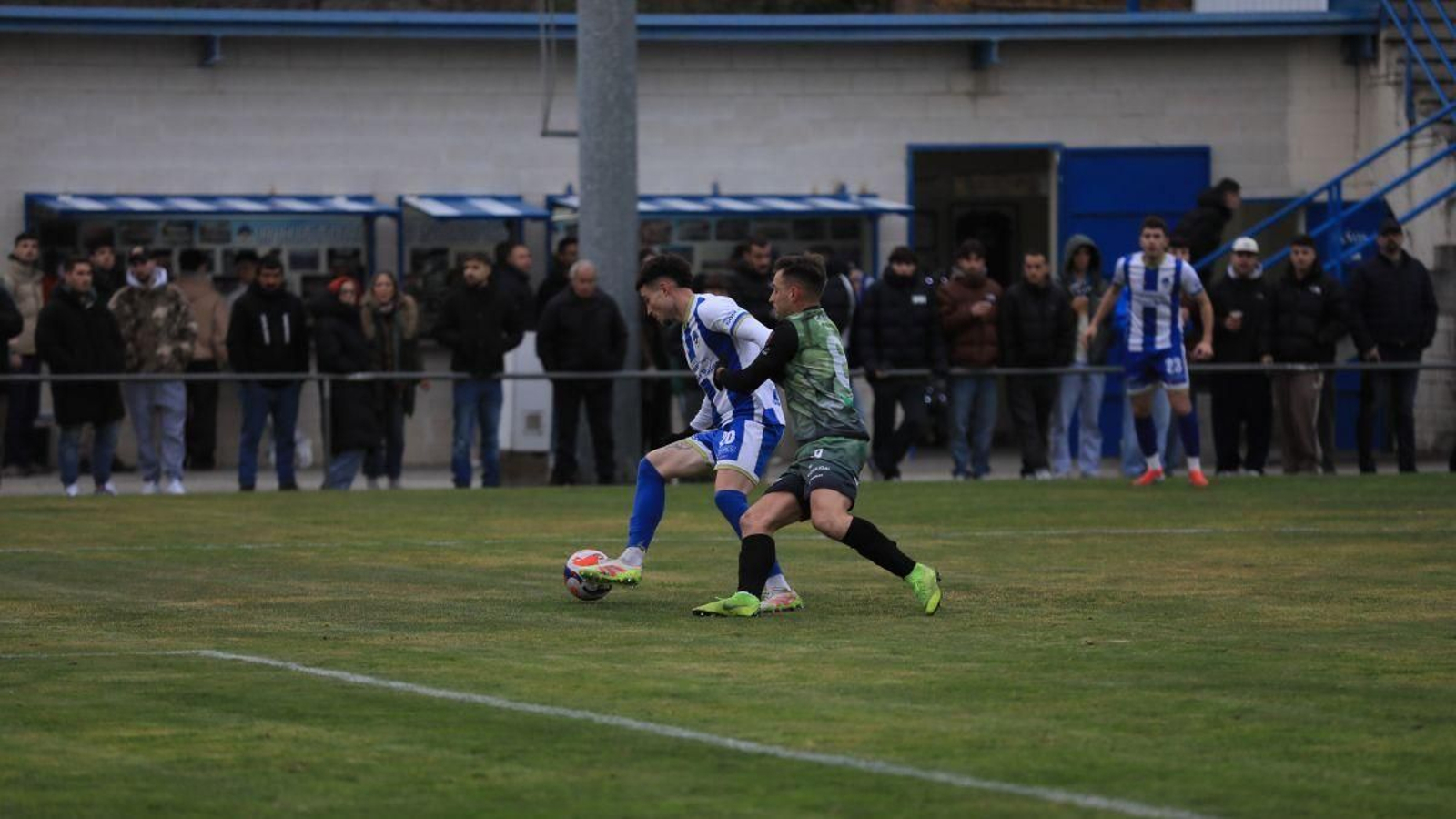 Coello, defensa del Celanova, aguanta el balón ante la presión de Rivero, del Atlético Arnoia.