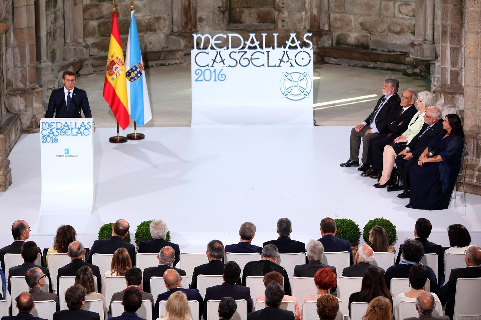 Feijóo, durante su intervención en el acto de Bonaval, con los premiados sentados a su izquierda.