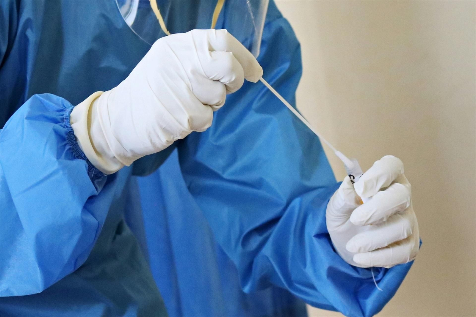 Un sanitario con una PCR para detectar el virus.