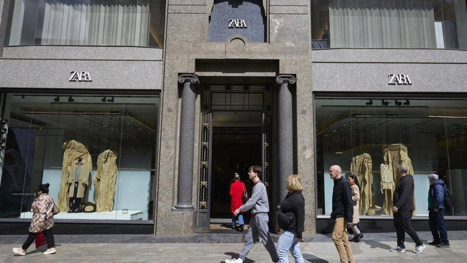 Un grupo de personas pasan por delante de una tienda de Zara, en Madrid.