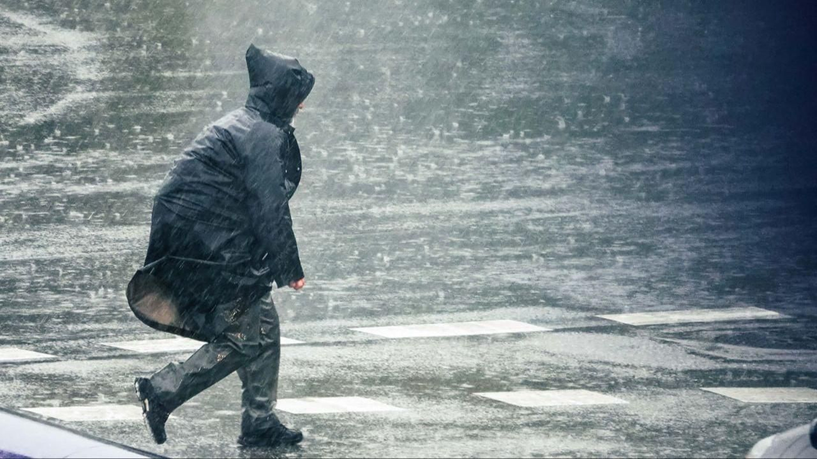 Una persona, bajo la lluvia.