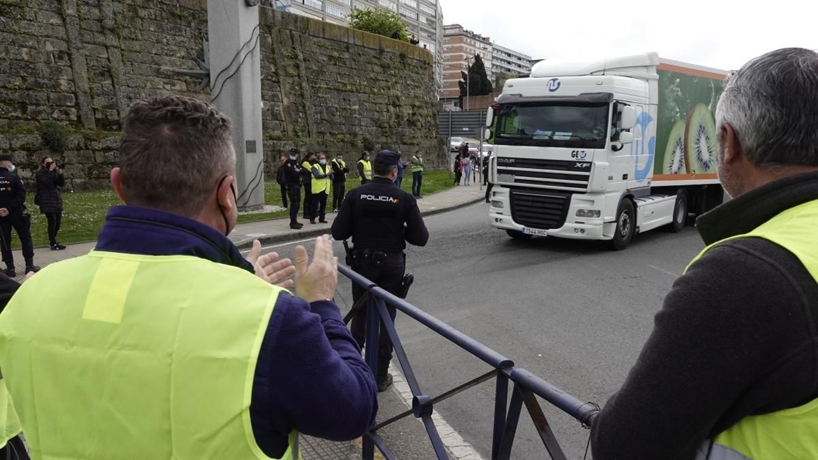 Camiones saliendo de O Berbés ayer con protección policial ante los piquetes.