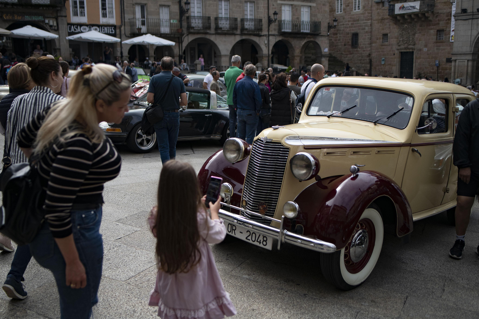 Niña ante un coche de rally clásico en la Plaza Mayor de Ourense