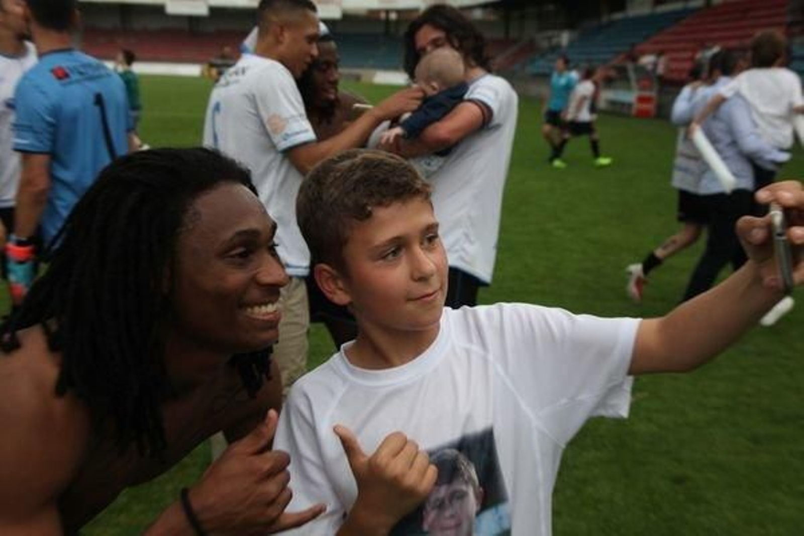 Un joven aficionado se saca una foto con el jugador del Ourense CF Anderson Cruz.