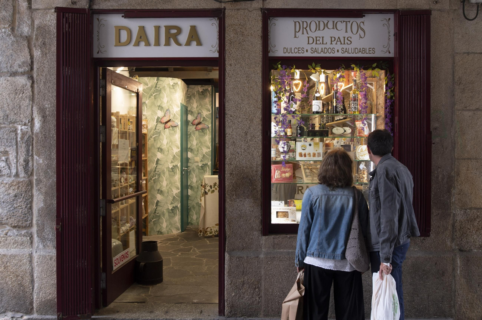 Dos personas observan un escaparate con productos típicos del país.