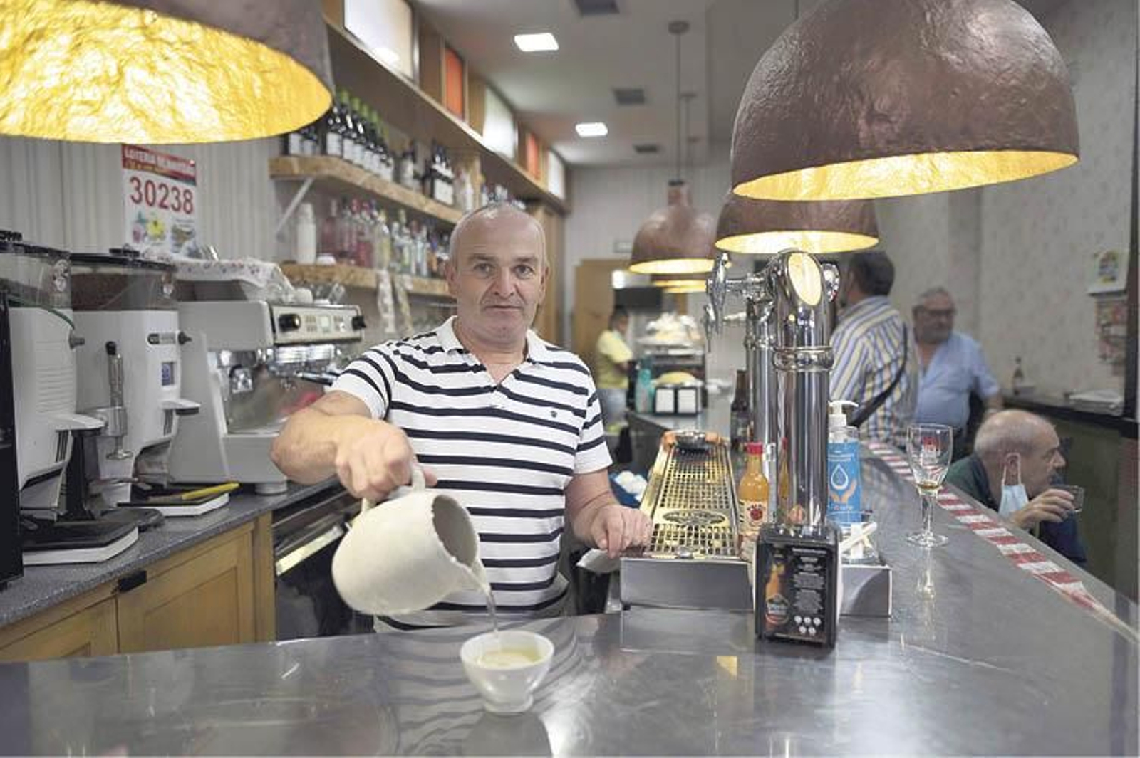 Juan Lucas Martínez sirviendo un vino al modo tradicional en el Bar Capilla. (Martiño Pinal)