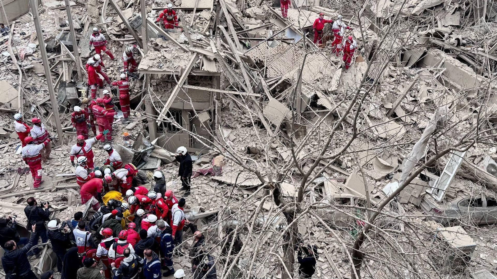 Equipos de rescate de la Media Luna Roja Iraní (IRCS) trabajan en el lugar donde un edificio quedó destruido tras un ataque aéreo en Teherán.
