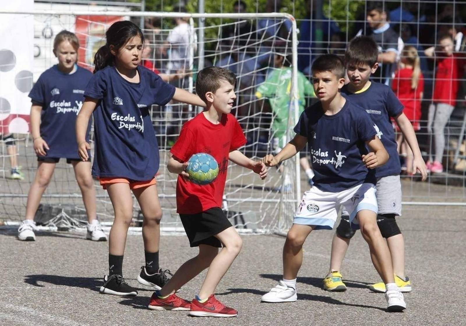 Niños y niñas jugando al balonmano.