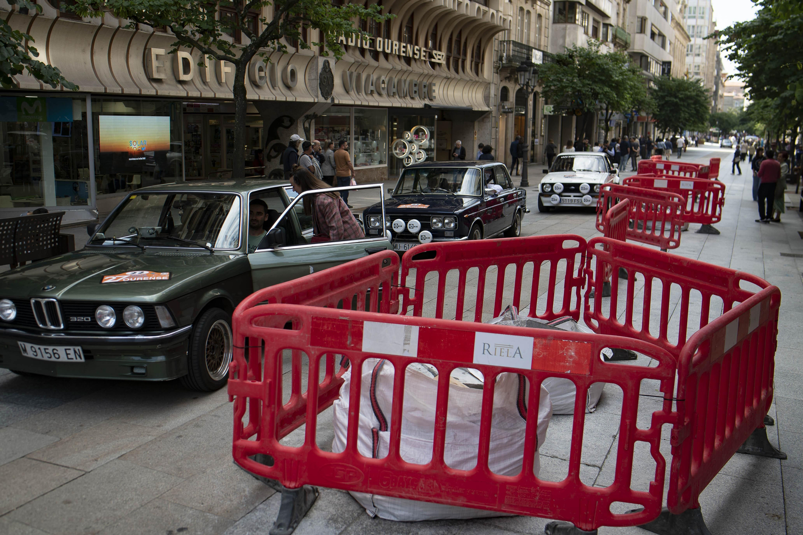 Coches del rally clásico circulando por la calle del paseo