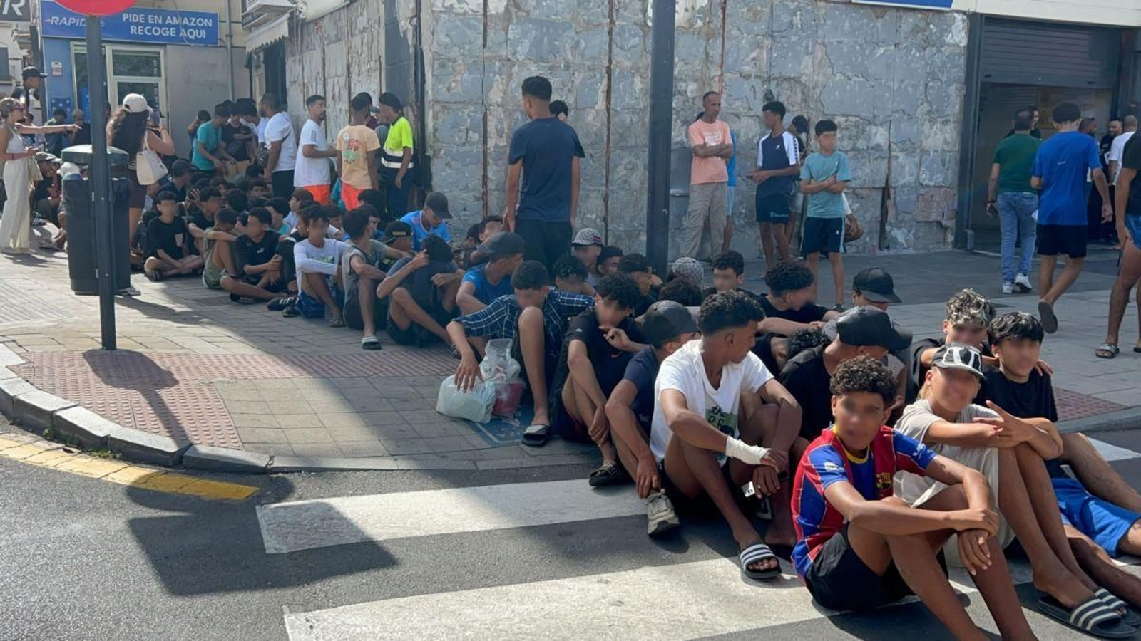 Menores marroquís hacen cola frente a la Comisaría de Ceuta.