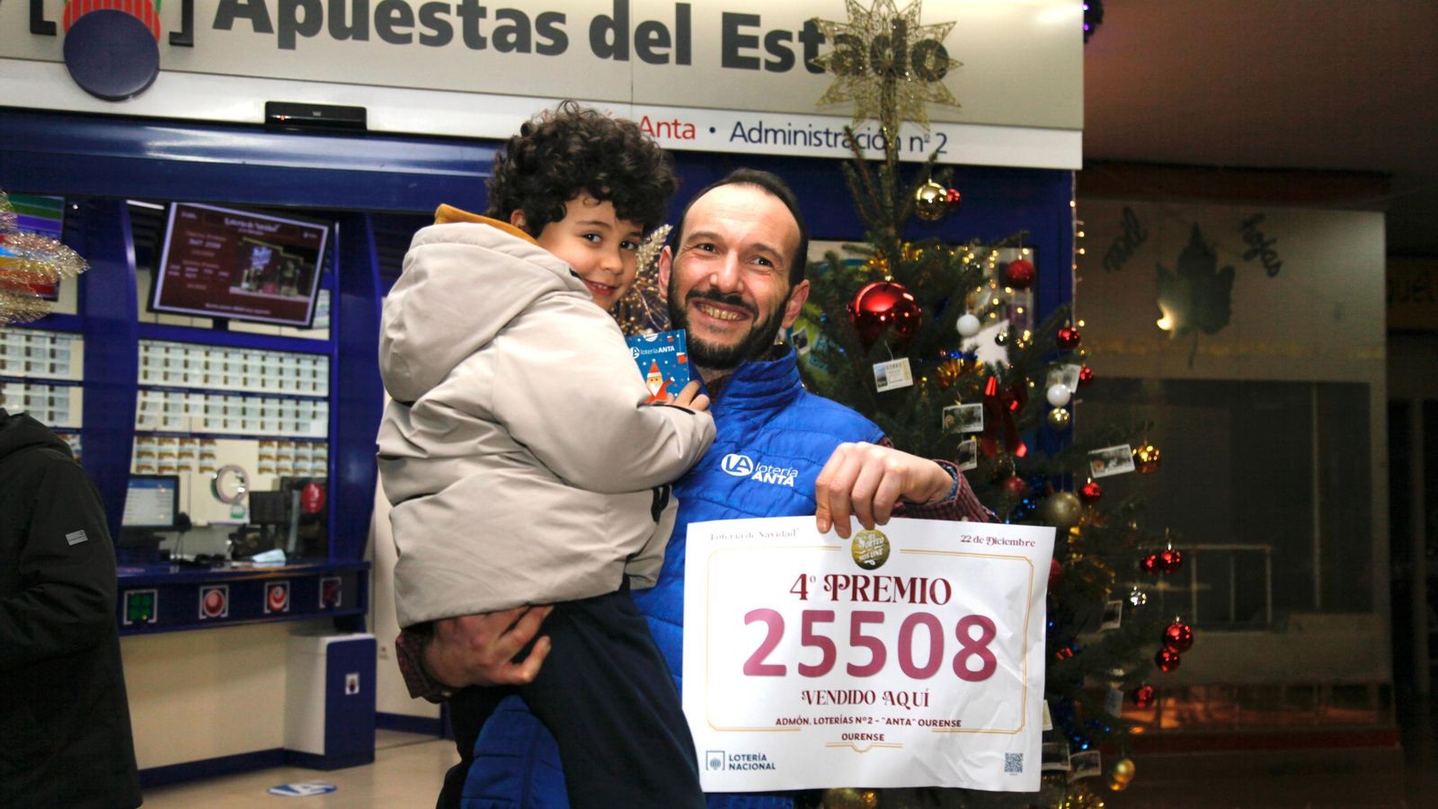 Jorge Anta, responsable de Loterías Anta, con su hijo Oliver muestra con orgullo los décimos del cuarto premio repartidos este año