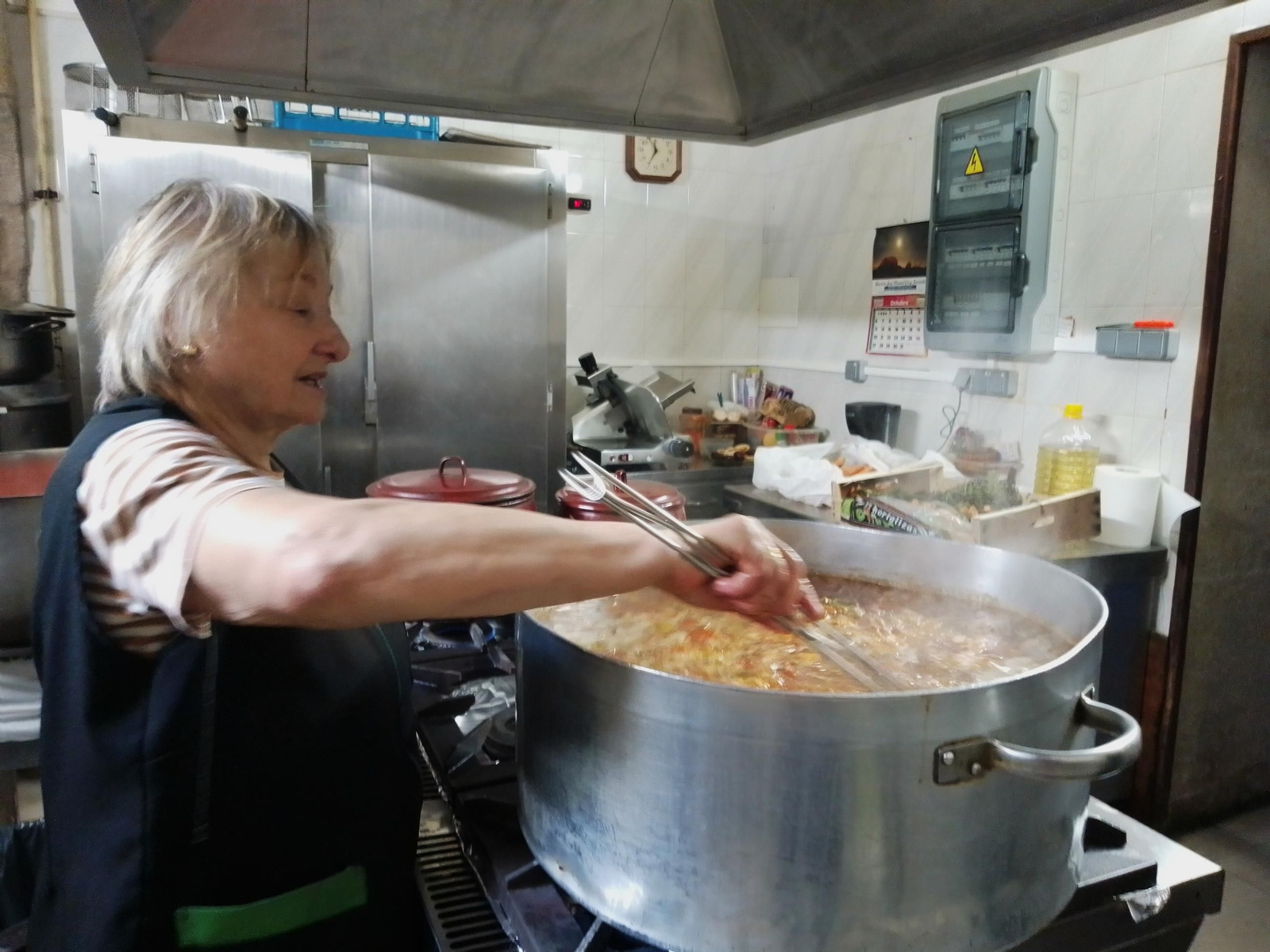 Carmen, cocinera del comedor de San Francisco, preparando arroz con carne en una de las ollas.