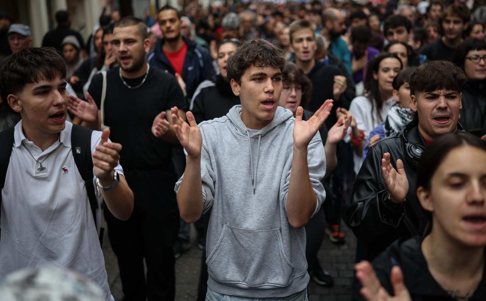 Manifestantes concentrados ante el cordón policial desplegado en los aledaños del Congreso de los Diputados durante la protesta en defensa del derecho a la vivienda