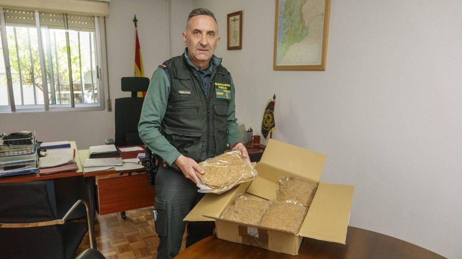 El cabo primero José Álvarez, junto a uno de los paquetes con tabaco de liar ilegal de los 193 kilos interceptados en los últimos meses (a la derecha).