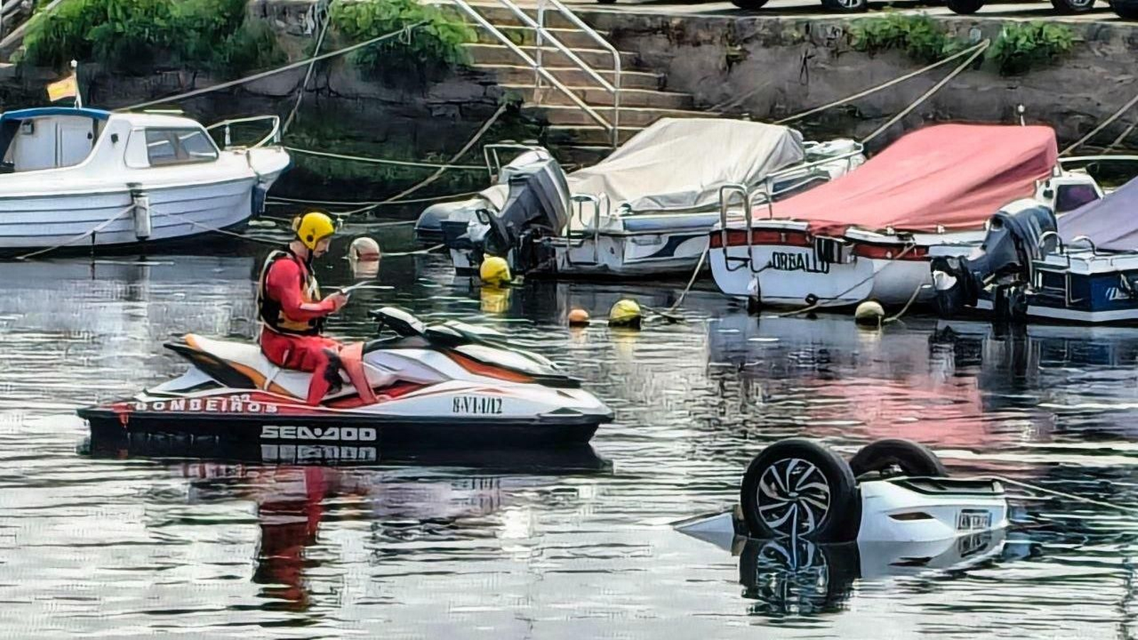 El vehículo, hundido y boca abajo, en el muelle de As Corvaceiras.