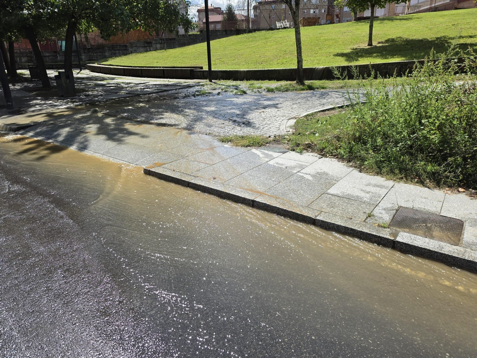El agua inunda y llena de barro la Plaza Pablo Iglesias tras la rotura de una tubería.