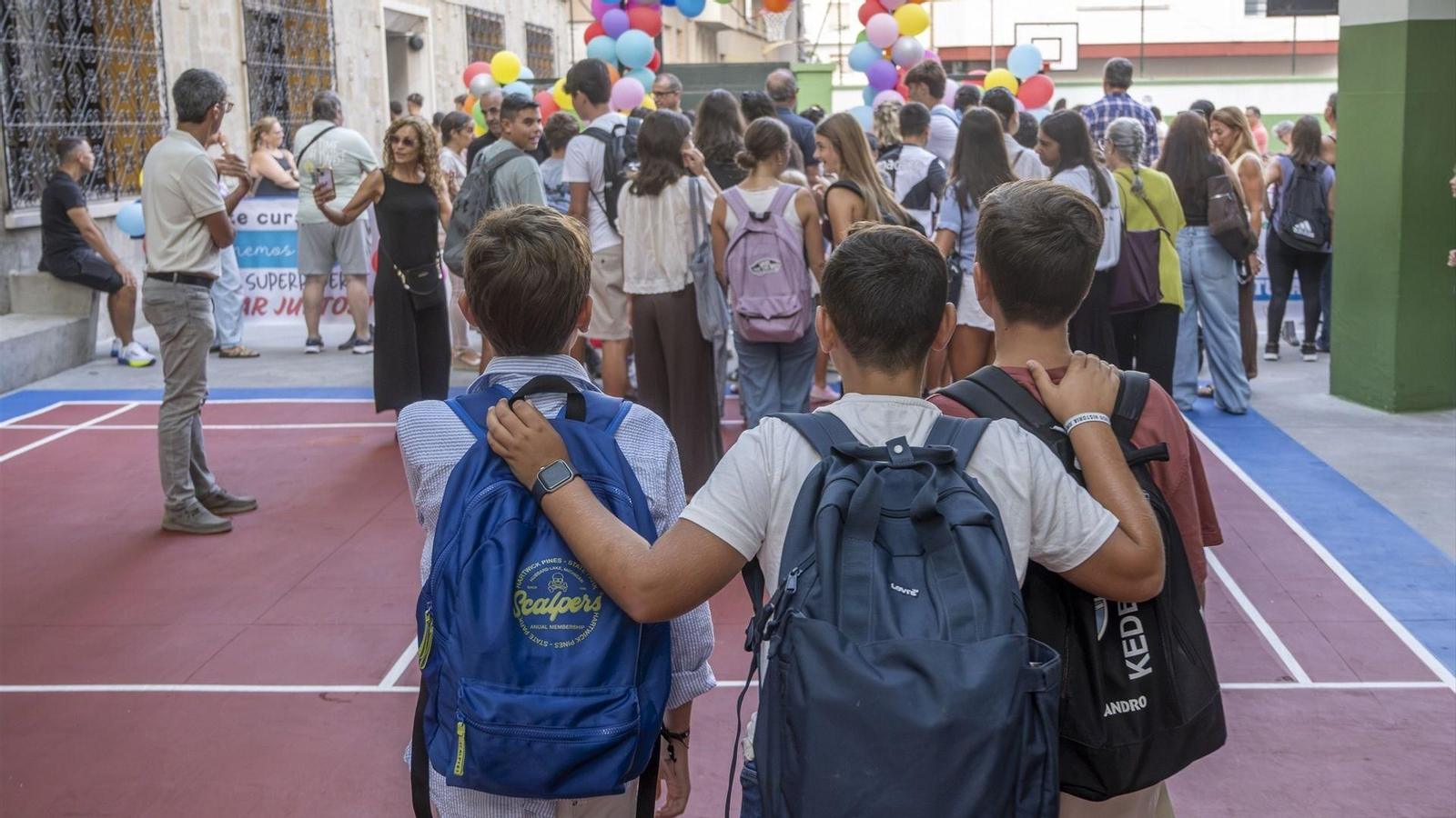 Un grupo de alumnos en la entrada de un colegio.