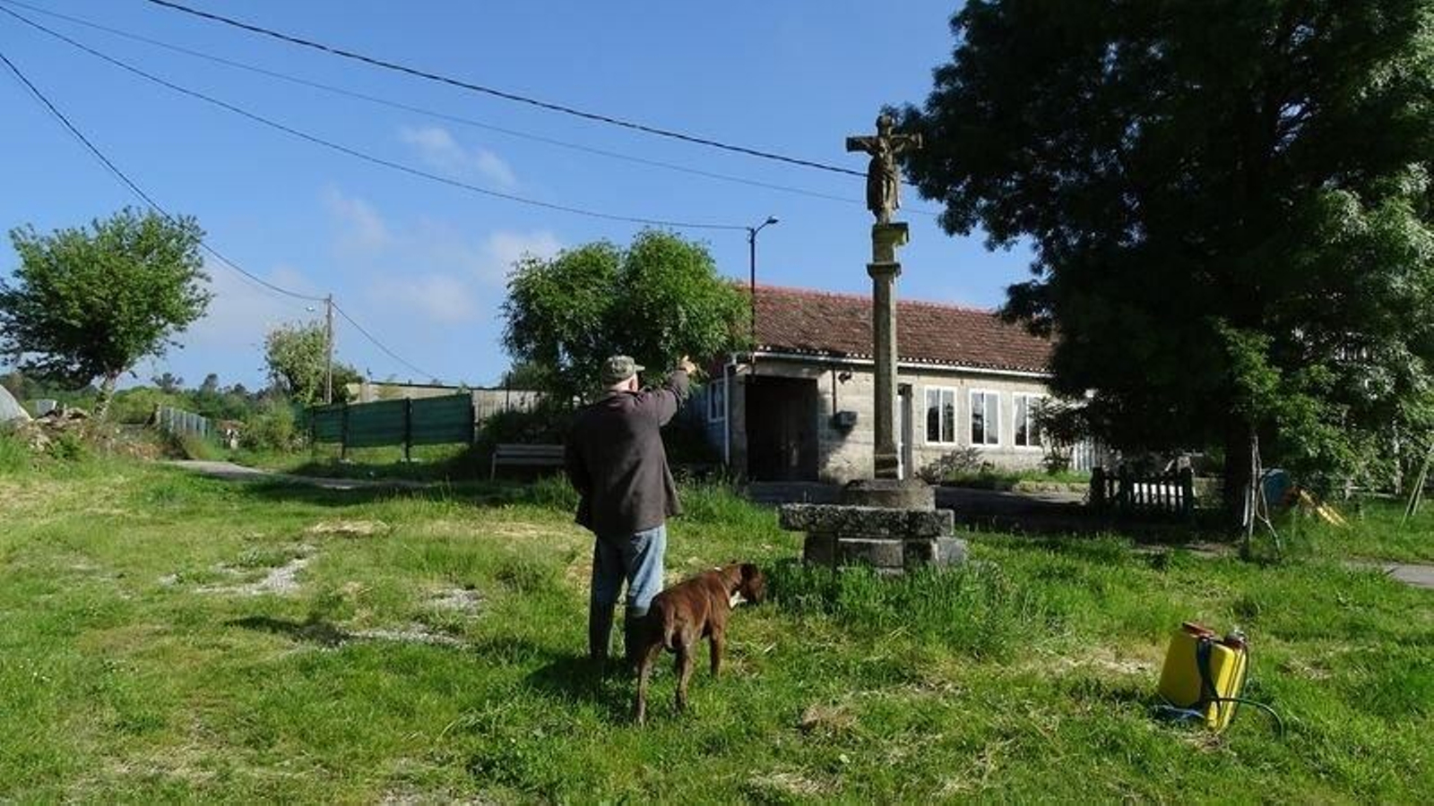 Un vecino muestra el cruceiro y la rotura que sufrió al pie de la imagen.