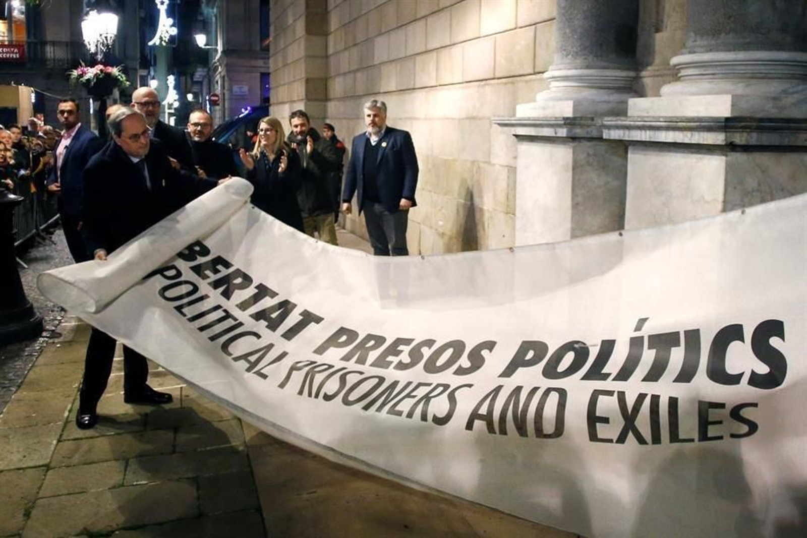 El presidente de la Generalitat Quim Torra (i) muestra la pancarta por la que la Junta Electoral Central le ha sancionado, ordenando que se le retire su credencial de diputado autonómico, lo que conlleva su inhabilitación, hoy viernes en Barcelona. EFE/Quique García