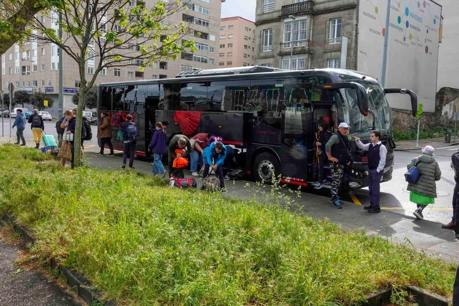 Viajeros bajándose de un autobús en Vigo.