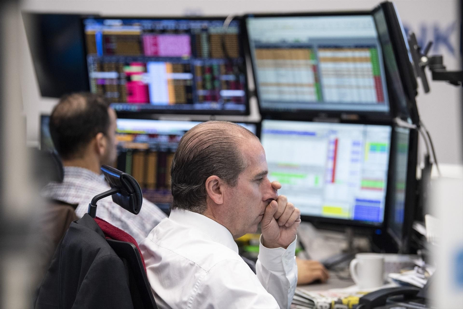 Traders analizando los valores en los monitores de la Bolsa de Frankfurt