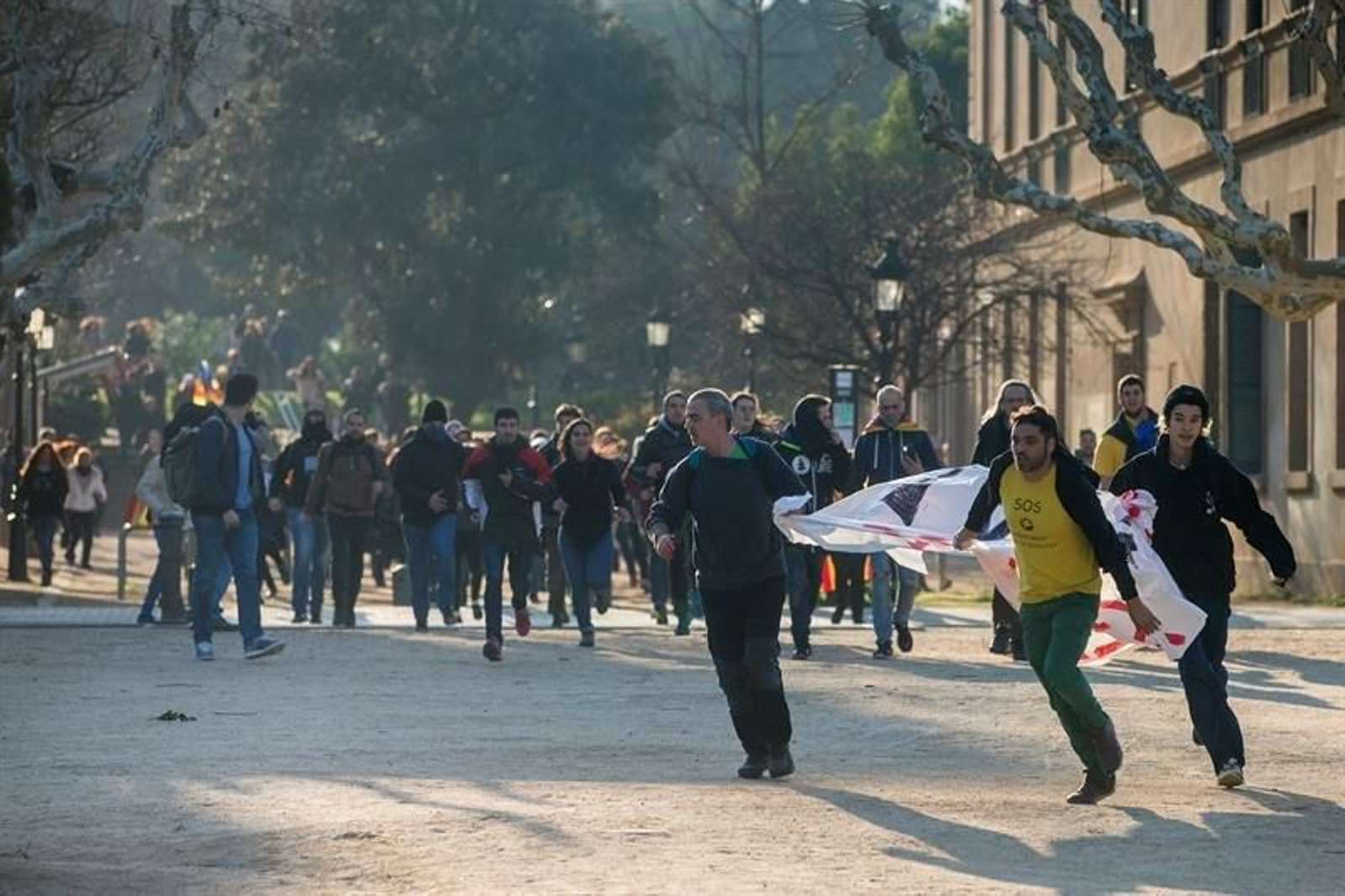 Manifestantes a la carrera en el interior del Parque de la Ciudadella, tras desbordar el cordón policial.