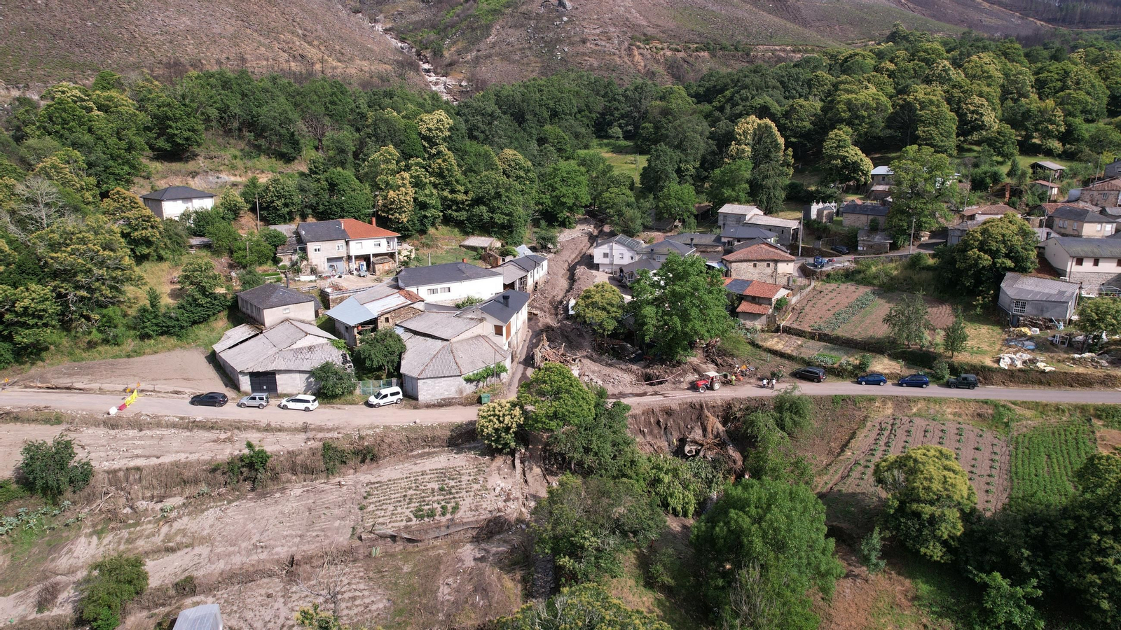 Imagen aérea de A Bouza. Al fondo el cauce por el que arroyó el agua, mezclada con barro, troncos  y piedras.