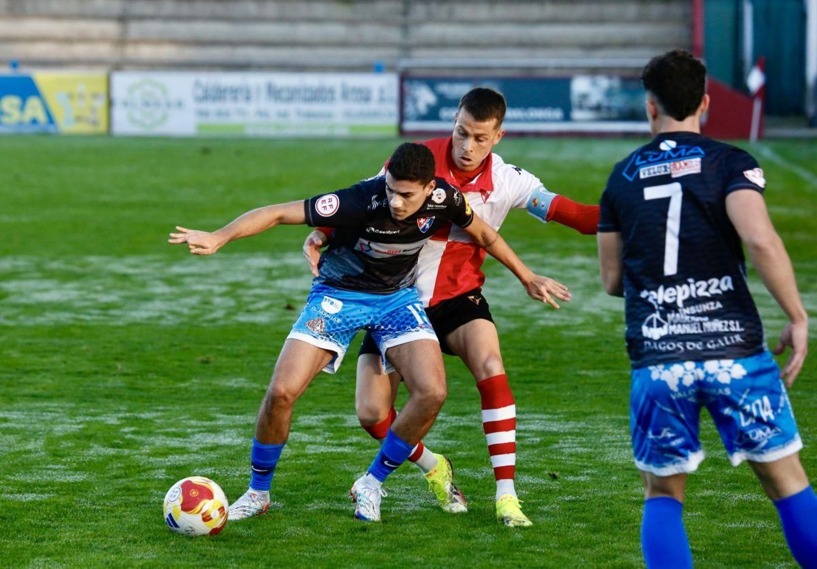 Miguel Freiría controla el esférico ante la presión de un rival del Arosa en A Lomba