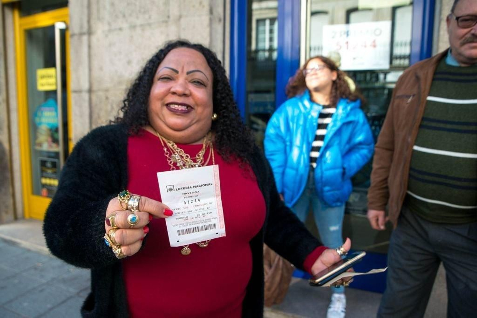 Elsa Altagracia muestra la combinación ganadora frente a la administración de lotería de Xinzo.