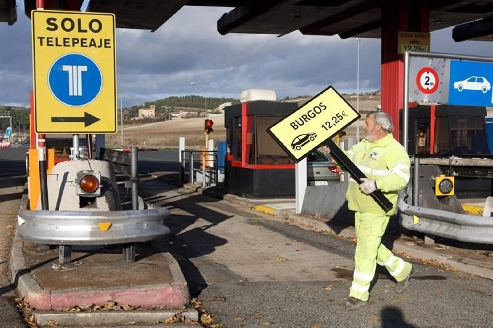 Un operario retira hoy la señalización del peaje alavés de Armiñón de la autopista AP-1