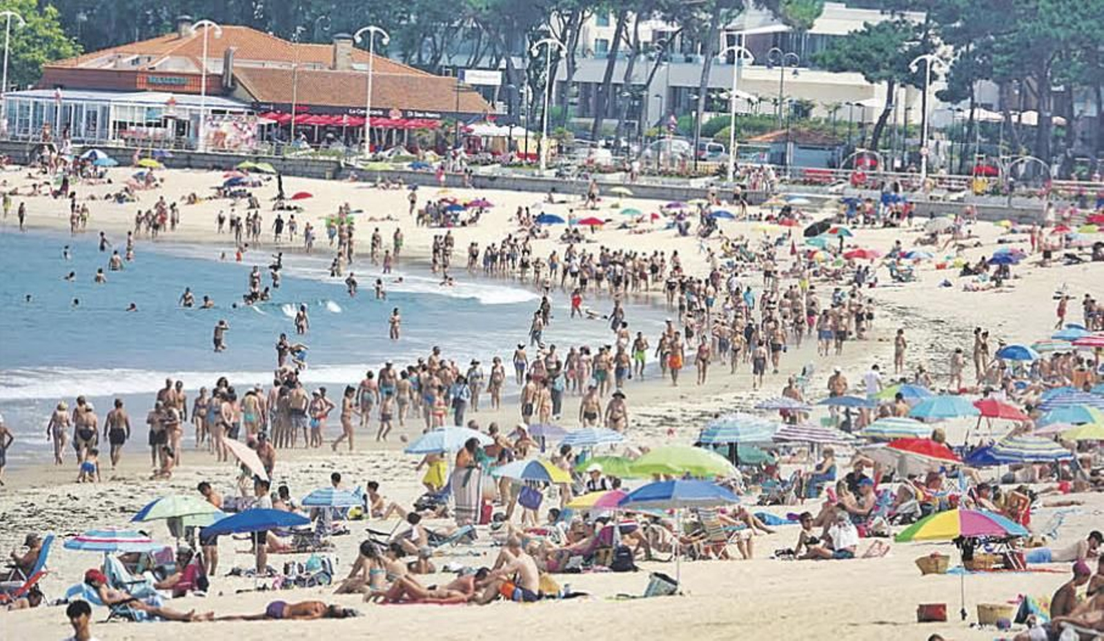 Una multitud de bañistas disfrutando de una jornada calurosa de verano en la playa de Samil.