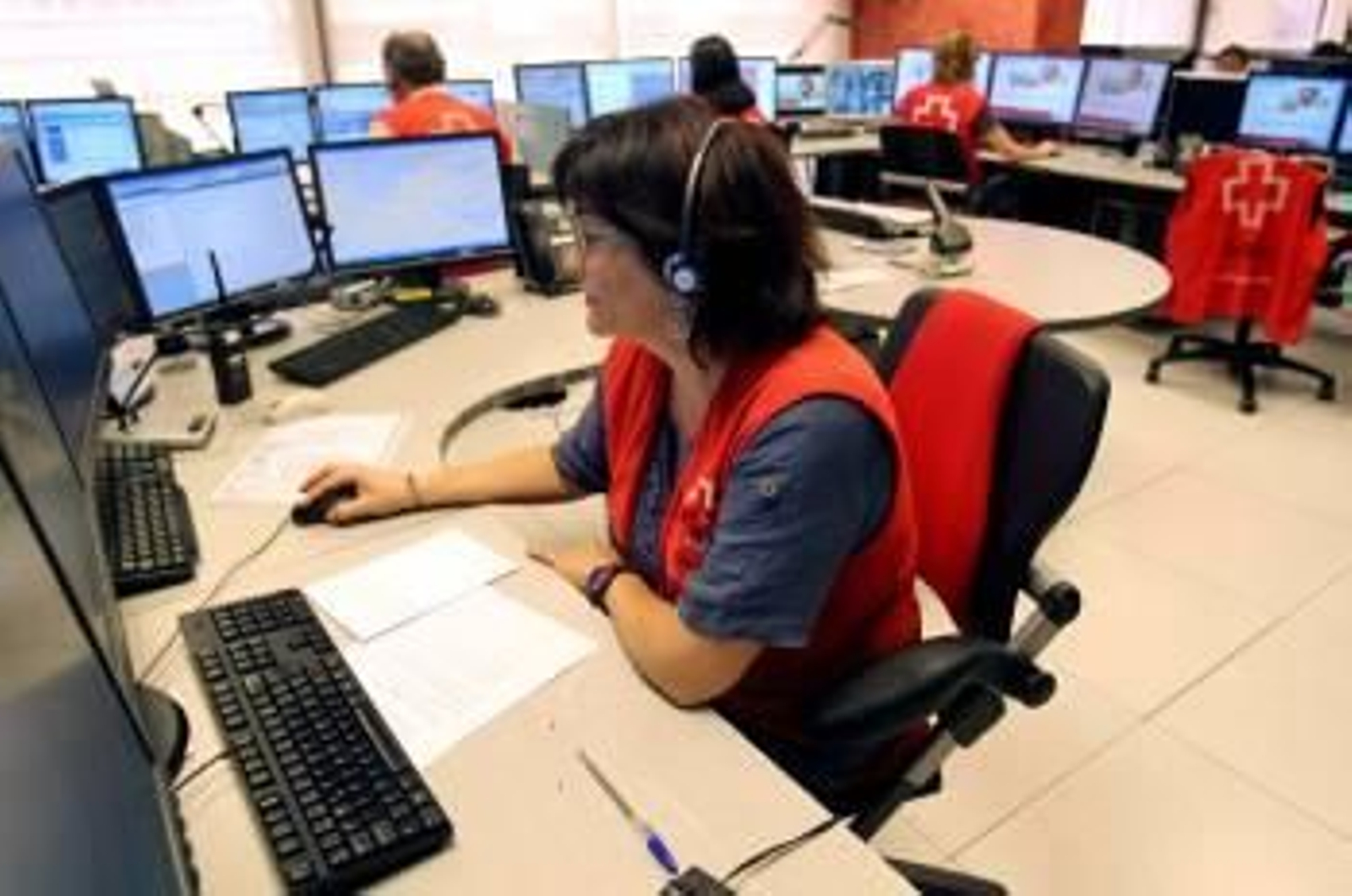 Una operadora atiende a un anciano desde el centro de coordinación de la Cruz Roja. (Foto: TONI ALBIR)