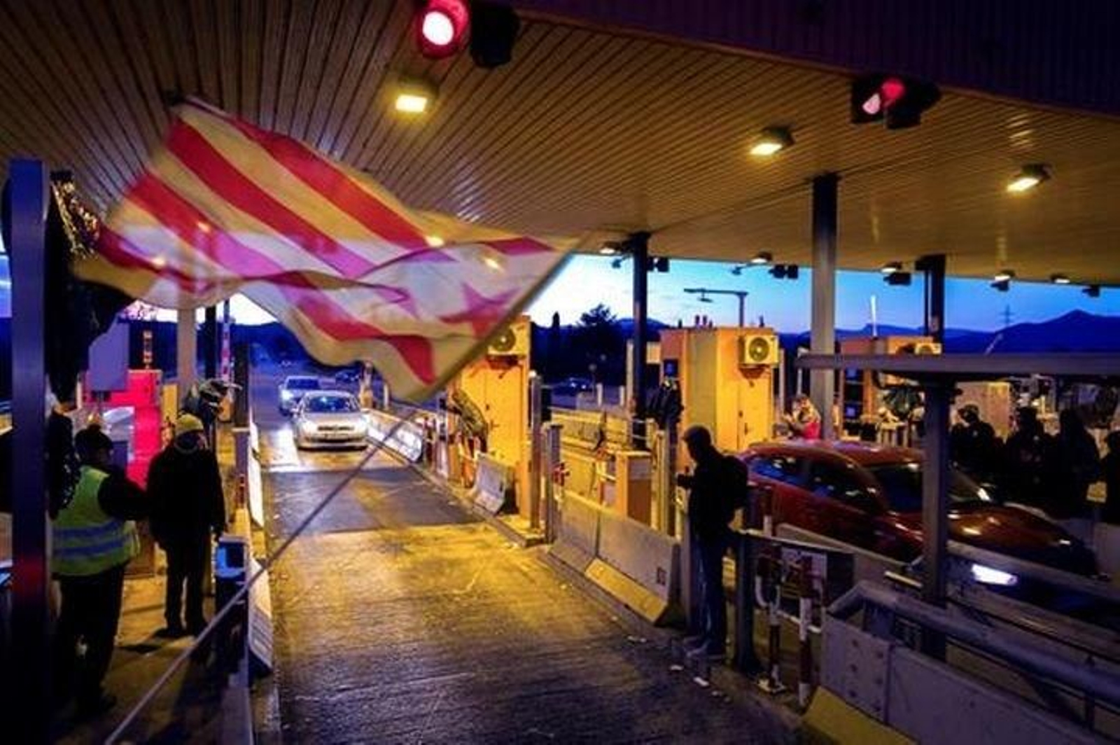 Un grupo de los Comités de Defensa de la República (CDR) levantan las barreras en la salida de la AP-7 en Girona Sud.