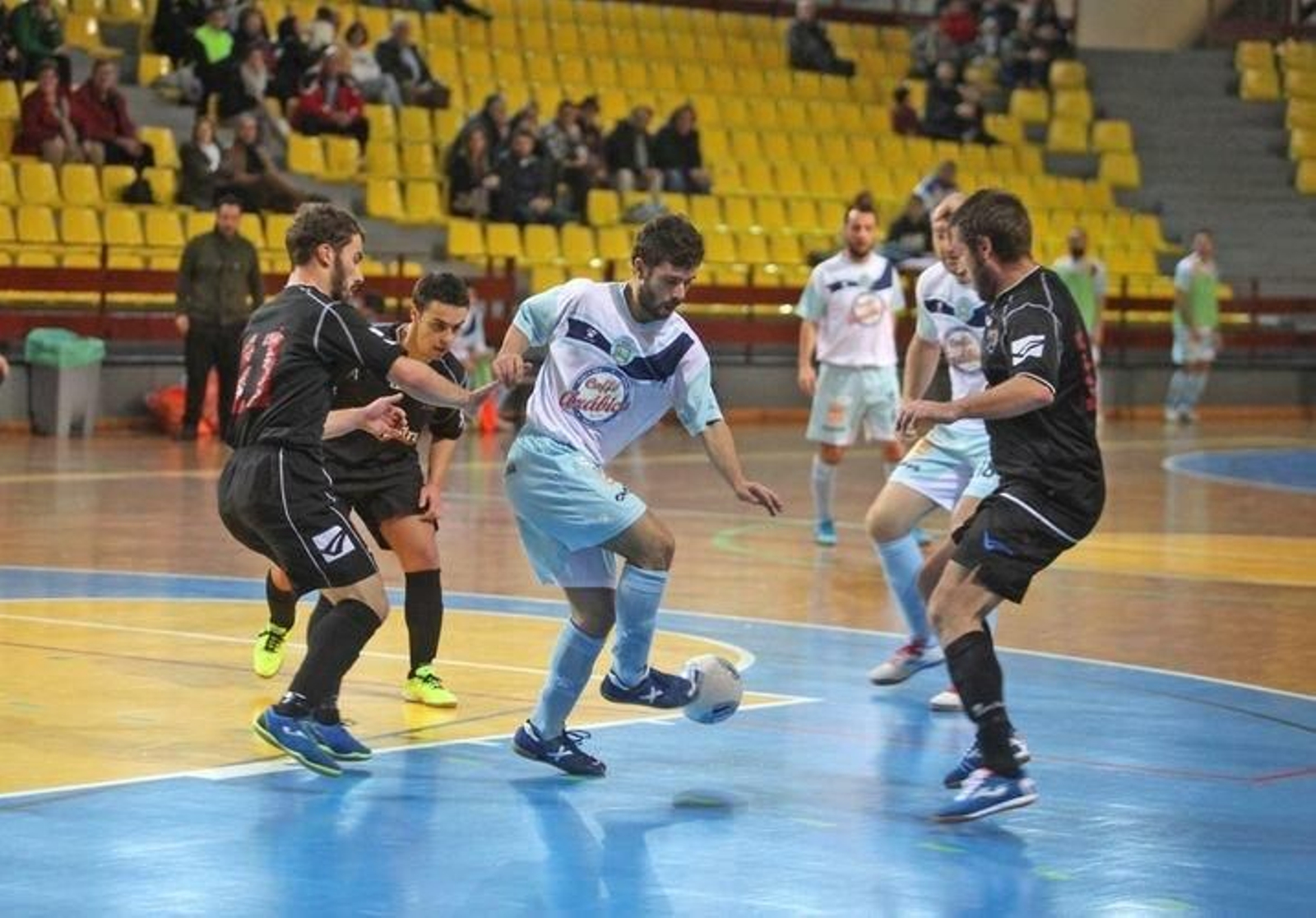 Un jugador del Sala Ourense, rodeado de rivales del Lume Bamboo.