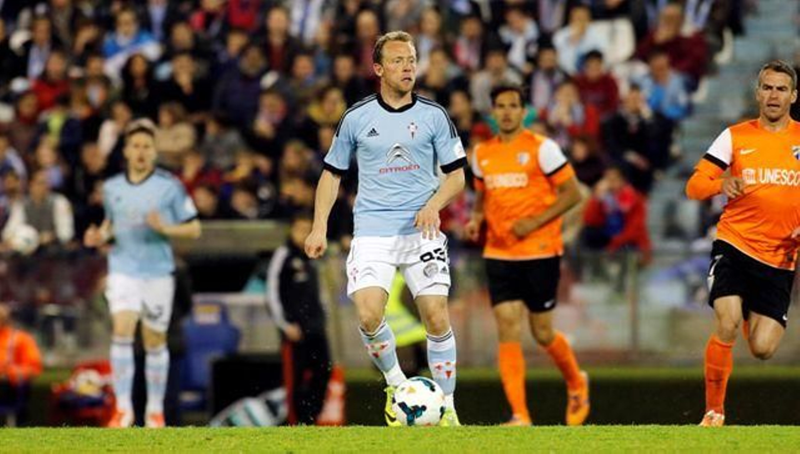 Michael Krohn-Dehli busca el pase ante el malaguista Duda durante el partido de ayer en Balaídos.