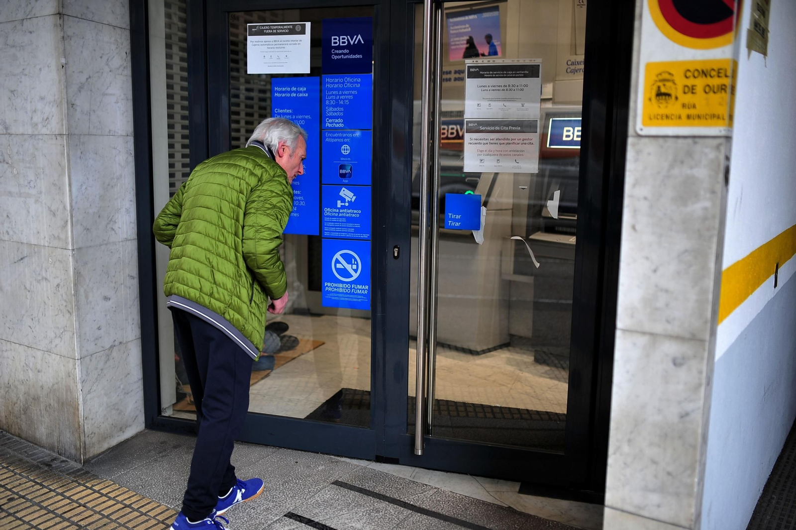 Un ourensano entrando en una sucursal bancaria.