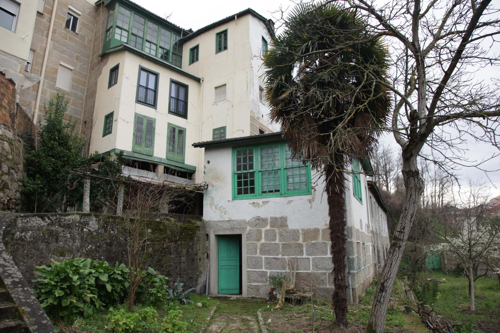 Trasera del edificio y jardín a orillas del Barbaña.