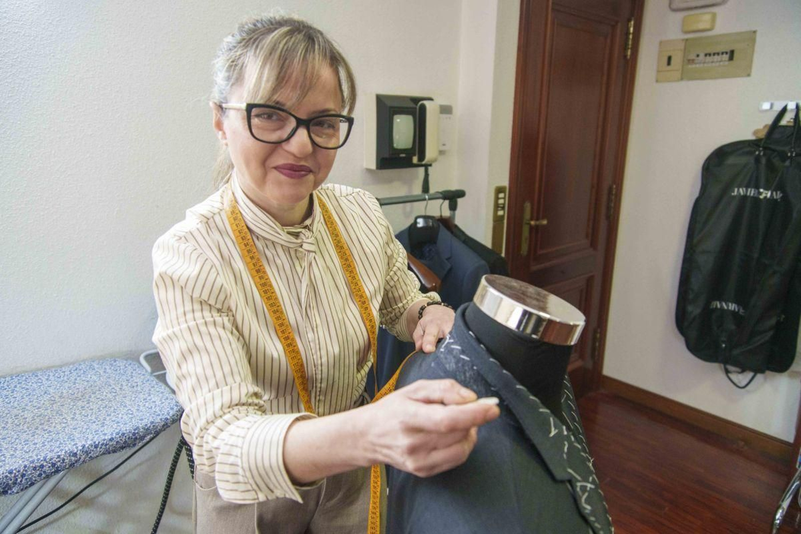 Lidia Nadylkova arregla un traje en su taller de la calle Gerona