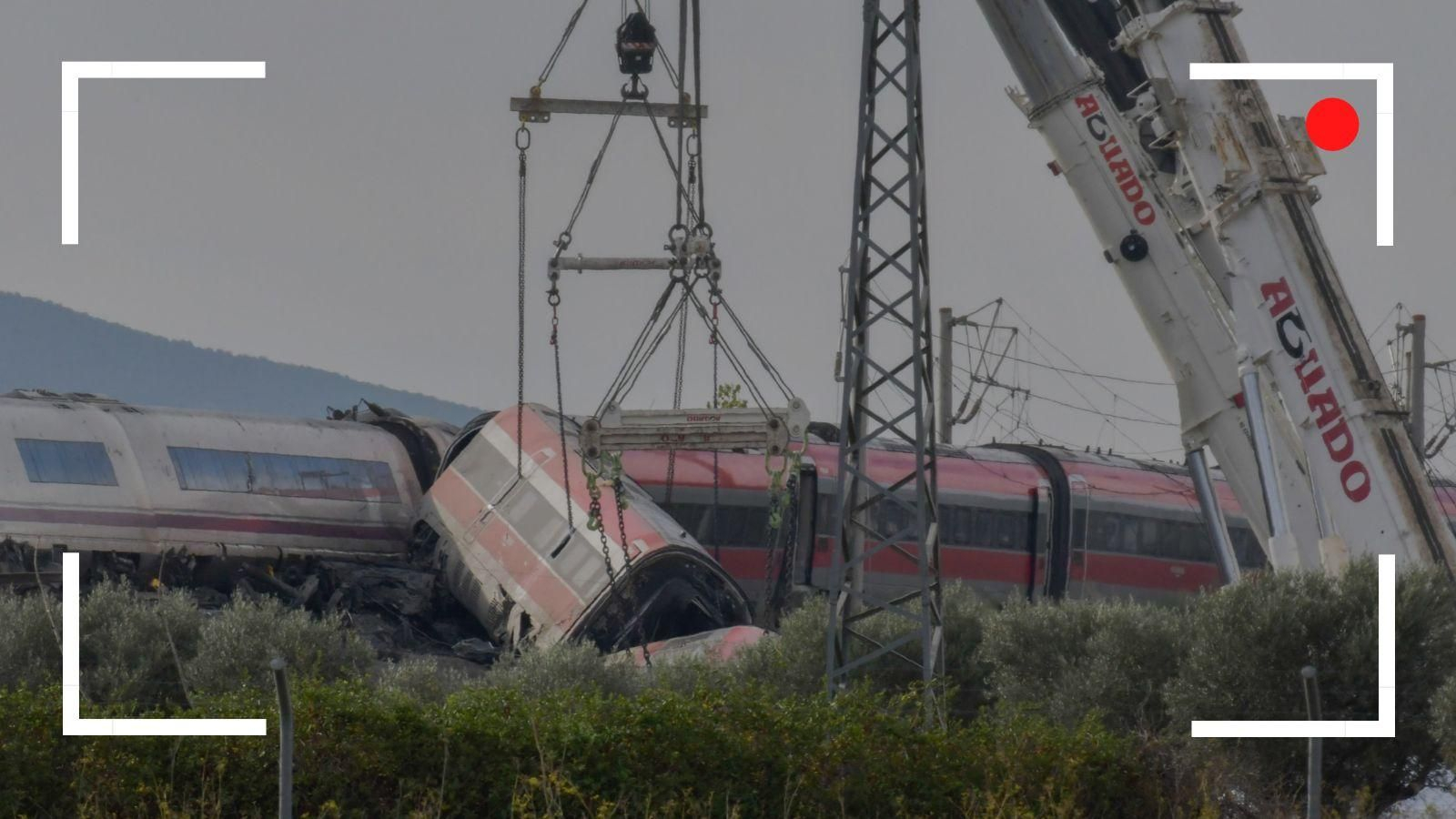 Dos grúas trabajan para retirar los vagones de los trenes accidentados.