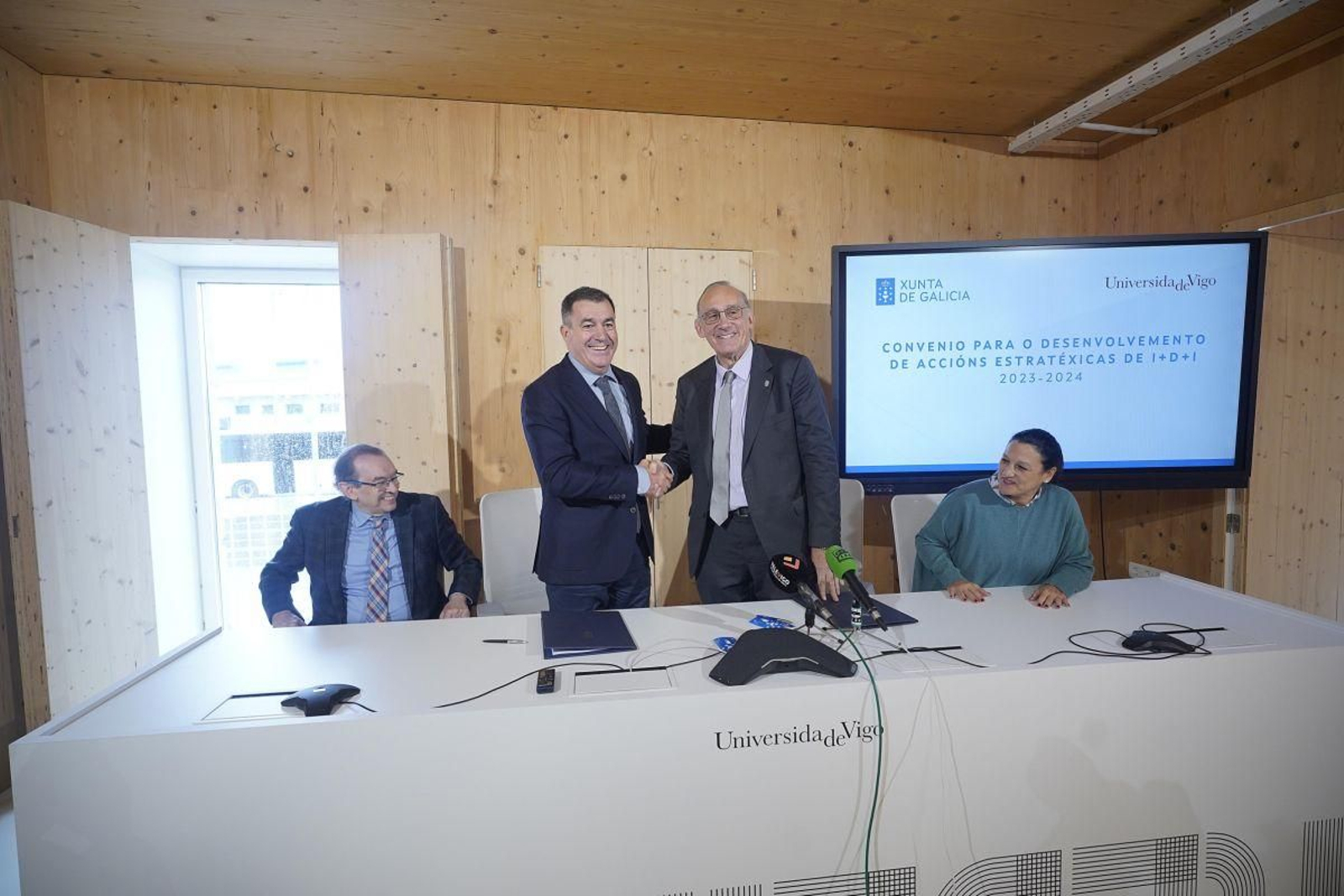 Reigosa y Rodríguez estrechando las manos tras la firma del convenio en el Edificio Redeiras en O Berbés.